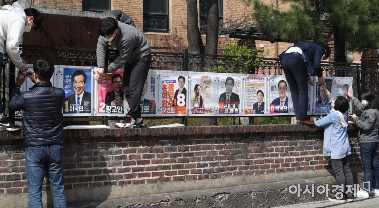 제21대 국회의원선거 공식 선거운동이 시작된 2일 서울 종로구 예술가의 집 울타리에 선관위 직원들이 선거벽보를 첩부하고 있다./김현민 기자 kimhyun81@