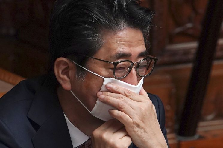 아베 신조 일본 총리가 3일 참의원 본회의에 참석, 쓰고 있던 마스크를 조절하고 있다. [이미지출처=AP연합뉴스]