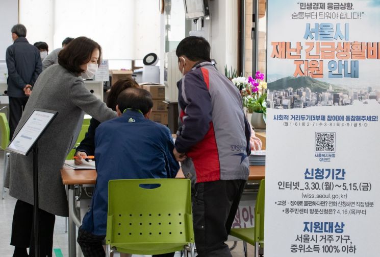지난달 30일 ‘서울시 재난 긴급생활비’ 신청이 시작됐다. 사진은 이날 송파구 마천2동주민센터에서 직원들이 주민들에게 재난 긴급생활비를 안내하고 있는 모습