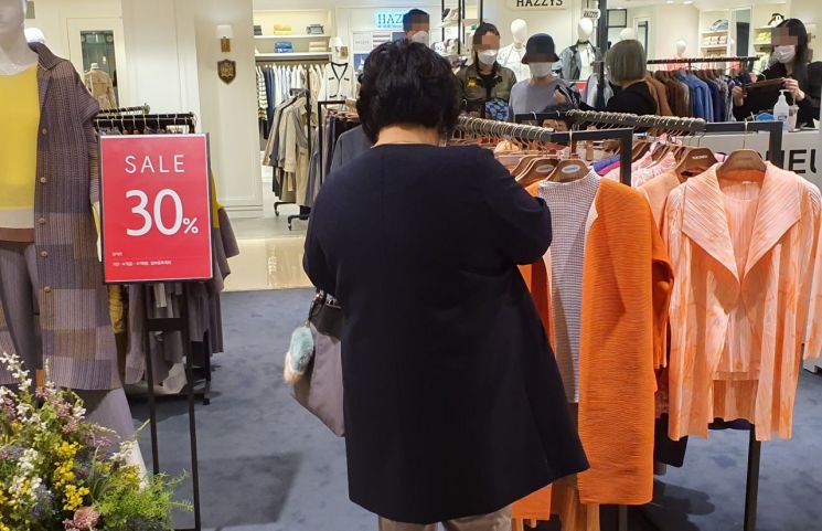 서울 중구 롯데백화점 본점 의류매장에서 한 고객이 봄 옷을 살펴보고 있다.