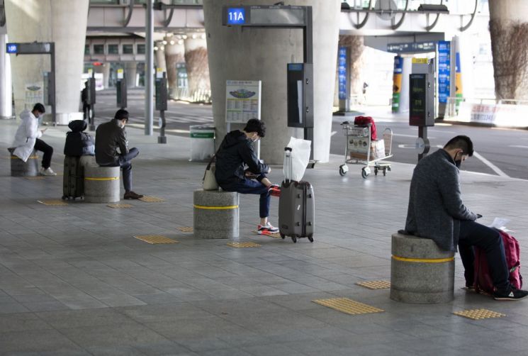 6일 오전 인천국제공항 1터미널 입국장에서 버스를 기다리는 입국자들이 떨어져 앉아 있다. [이미지출처=연합뉴스]