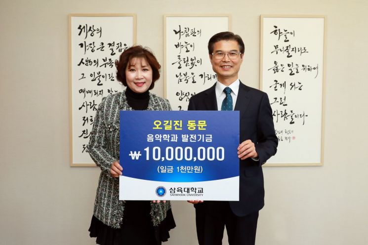 오길진(왼쪽) 삼육대 피아노동문장학회 회장이 김일목 총장에게 장학금 1000만원을 전달하고 있다. (제공=삼육대학교)