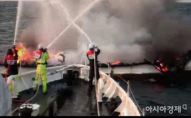 해양경찰이 화재가 발생한 제주선적 어선 광해호(9.77t)에 접근해 불을 끄고 있다. [제주 서귀포해경 제공영상 캡처]