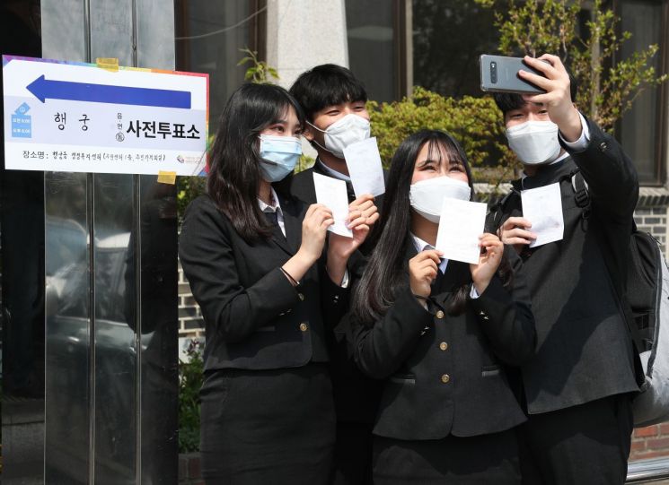제21대 국회의원선거 사전투표 첫날인 10일 오후 경기도 수원시 팔달구 행궁동 행정복지센터에 설치된 사전투표소에서 선거연령 하향조정으로 처음으로 투표권을 행사한 삼일공업고등학교 학생들이 투표확인증을 들고 기념촬영을 하고 있다. [이미지출처=연합뉴스]