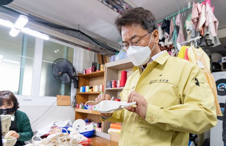 김선갑 광진구청장이 봉제공장을 찾아 면마스크를 살펴보고 있다.