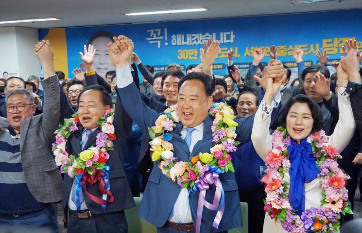 충남 당진시에 출마한 어기구 더불어민주당 후보가 15일 밤 자신의 선거사무소에서 꽃다발을 목에 걸고 환호하고 있다. [이미지출처=연합뉴스]
