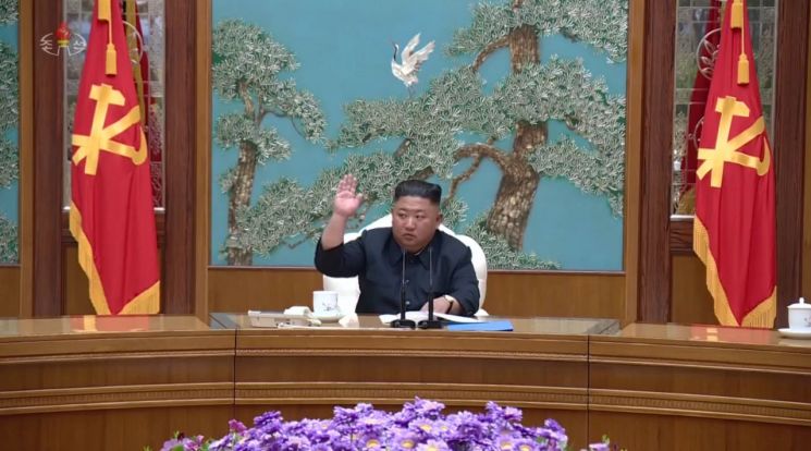 조선중앙TV는 12일 전날 당중앙위원회 본부청사에서 열린 노동당 정치국 회의 현장 사진을 보도했다. 김정은 국무위원장이 오른손을 들고 있다.