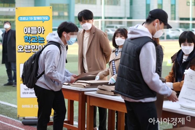 24일 서울 영등포구 여의도고등학교에서 학생들이 신종 코로나바이러스 감염증(코로나19) 확산 방지를 위해 워크스루 방식으로 전국연합학력평가 시험지를 받고 있다. /문호남 기자 munonam@