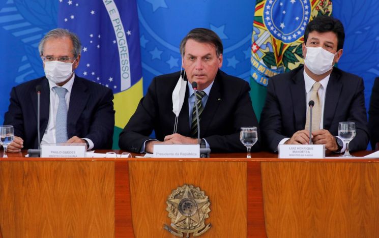 자이르 보우소나루 브라질 대통령(가운데)이 3월18일(현지시간) 수도 브라질리아에서 신종 코로나바이러스 감염증(코로나19)과 관련한 긴급 기자회견을 열고 방역 대책을 설명하고 있다. (사진=AFP연합뉴스)