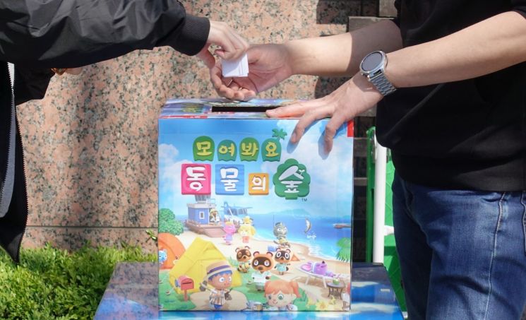 지난달 23일 오전 서울 구로구 구로동 신도림 테크노마트 앞에서 한 시민이 닌텐도 스위치 동물의숲 에디션 구매 응모를 하고 있다/사진=연합뉴스