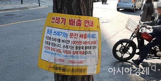 한 가로수에 내걸린 '쓰레기 안내 배출 문구'. 모든 쓰레기는 문 앞 배출을 원칙으로 한다는 내용이 담겨있다. 사진=한승곤 기자 hsg@asiae.co.kr