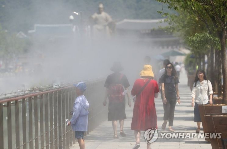 지난해 7월4일 서울 광화문광장에서 시민들이 쿨링포그가 작동되는 길을 따라 걷고 있다. / 사진=연합뉴스