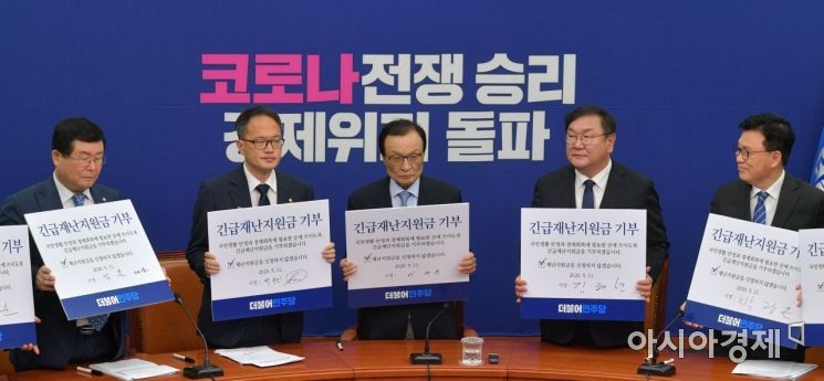 이해찬 더불어민주당 대표와 김태년 원내대표 등 당 지도부가 11일 국회에서 열린 최고위원회의에 참석, 회의 시작에 앞서 긴급재난지원금을 기부하기로 서명 후 포즈를 취하고 있다./윤동주 기자 doso7@