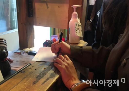 지난 9일 서울 용산구 이태원동 소재의 한 주점. 방문객이 명단을 작성하고 있다/사진=김연주 인턴기자 yeonju1853@asiae.co.kr