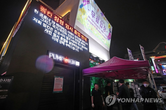 경기도 용인 66번 환자가 다녀간 서울 이태원 클럽에서 신종 코로나바이러스 감염증(코로나19) 추가 감염이 잇따르자 정부가 클럽 등 유흥시설을 대상으로 한 달 동안 운영 자제를 권고하는 행정명령을 내린 8일 오후 서울 이태원의 한 클럽에 자진 매장 앞에 임시 휴업 안내문이 스크린에 띄워져 있다. [이미지출처=연합뉴스]