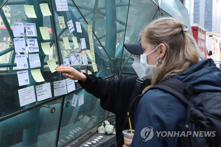 강남역 여성 살인사건 4주기를 맞은 17일 오후 서울 강남역 10번 출구 앞에서 외국인이 추모 메시지를 살펴보고 있다. [이미지출처=연합뉴스]