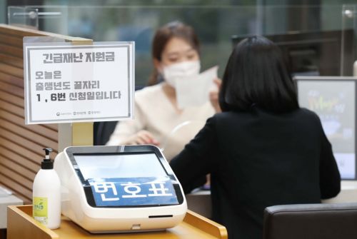 신종 코로나바이러스감염증(코로나19) 사태로 정부가 전 국민에게 지급하는 긴급재난지원금의 현장접수 첫 날인 18일 서울 중구 우리은행 본점에서 한 시민이 긴급재난지원금 관련 상담을 받고 있다. /문호남 기자 munonam@