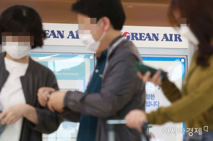 18일 서울 강서구 김포공항 국내선 청사 대한항공 체크인 카운터에서 승객들이 마스크를 쓰고 있다. 대한항공은 신종 코로나바이러스 감염증(코로나19) 확산 방지를 위해 오늘부터 국내선 탑승객의 마스크 착용 의무화를 시행한다. /문호남 기자 munonam@