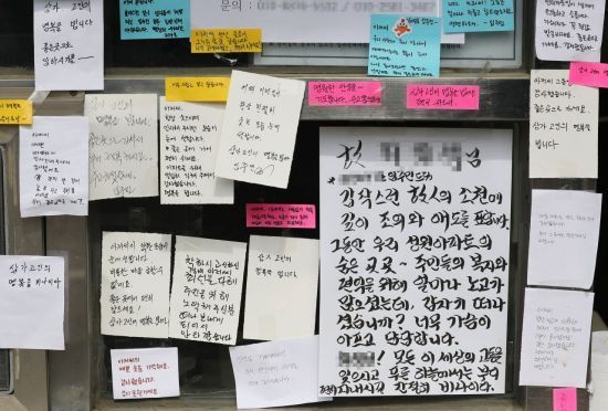'단지 내 주차 문제'로 시작된 한 주민과의 갈등 끝에 극단적 선택을 한 아파트 경비원 A씨가 근무하던 서울 강북구의 아파트 초소 앞에 지난 11일 주민들의 추모 메시지가 붙어 있다. [이미지출처=연합뉴스]