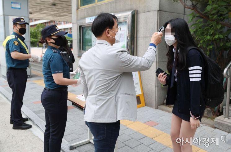 신종 코로나바이러스 감염증(코로나19) 사태로 미뤄진 등교수업이 재개된 20일 서울의 한 고등학교에서 3학년 학생들이 등교하며 발열 검사를 받고 있다. /문호남 기자 munonam@