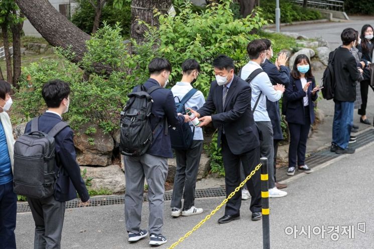 고등학교 3학년이 등교 개학을 시작한 20일 서울 종로구 경복고등학교에서 학생들이 등교하며 발열검사 및 손소독을 하고 있다./강진형 기자aymsdream@
