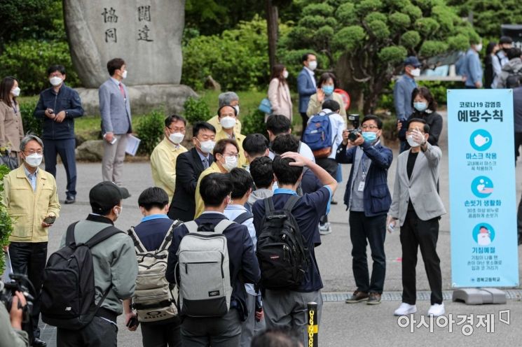 고등학교 3학년이 등교 개학을 시작한 20일 서울 종로구 경복고등학교에서 학생들이 등교하며 발열검사 및 손소독을 하고 있다./강진형 기자aymsdream@