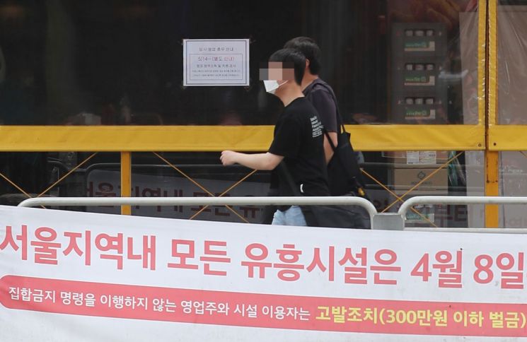 신종 코로나바이러스 감염증(코로나19) 확진자가 다녀가 임시 휴무 중인 서울 마포구 홍대 앞 주점 앞을  지난 17일 오후 시민들이 지나가고 있다. [이미지출처=연합뉴스]