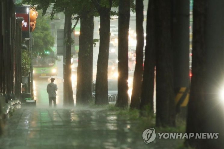 지난 18일 오후 서울 마포구의 한 거리에서 시민이 우산을 쓴 채 지나가고 있다. 사진=연합뉴스