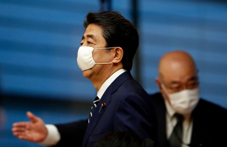 아베 신조(왼쪽) 일본 총리가 25일 마스크를 착용한 채 도쿄 총리관저의 기자회견장에 들어서고 있다. [이미지출처=연합뉴스]