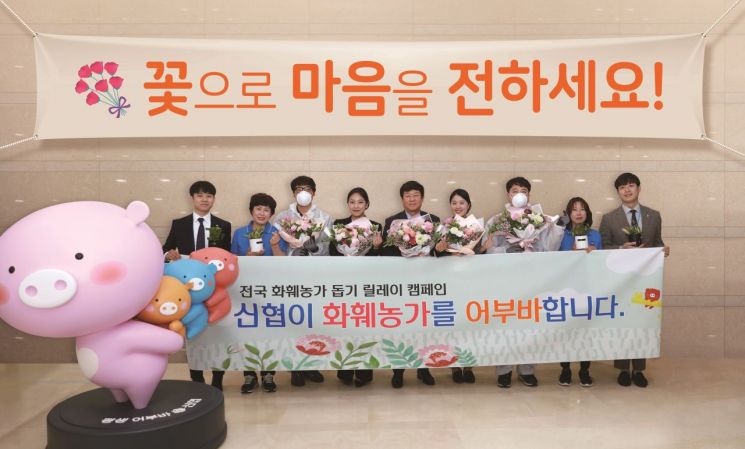 화훼농가 돕기 릴레이 캠페인에 나선 김윤식 신협중앙회장(가운데)이 직원들에게 꽃 화분과 전통시장 상품권을 전달한 뒤 기념사진을 찍고 있다. 사진=신협중앙회