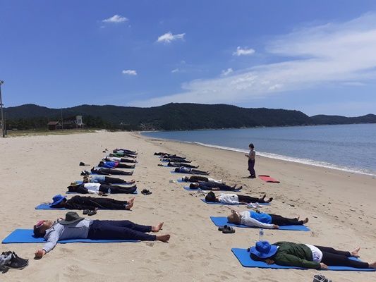 산소 음이온이 풍부하고 다양한 해양치유자원을 보유하고 있는 신지명사십리해수욕장에서 니드라 명상을 하고 있다. (사진=완도군 제공)