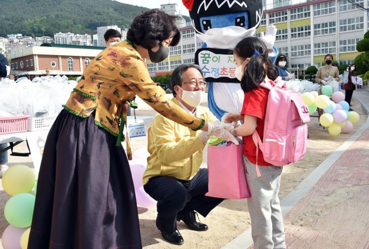 김석준 부산교육감이 27일 오전 부산 수정초등학교에서 등교하는 1~2학년생을 격려하고 있다.
