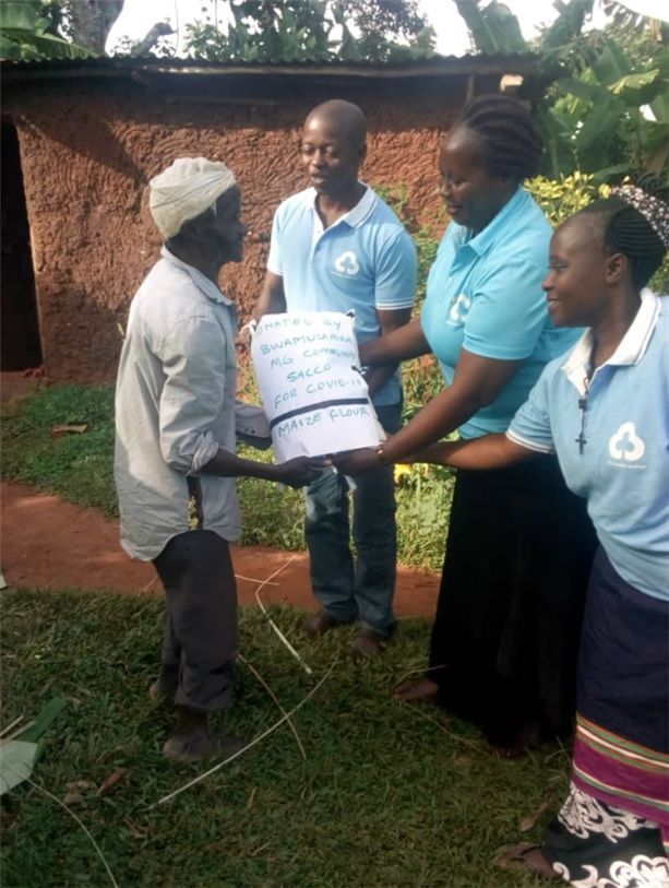우간다 새마을금고 직원들이 마을 주인에게 옥수수 가루를 전달하고 있다.