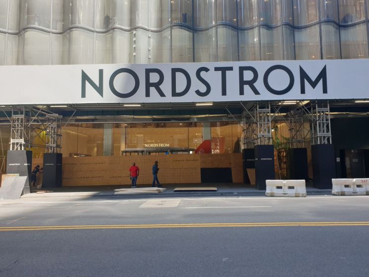 지난달 31일 맨해튼 소재 노드스트롬 백화점에서 인부들이 정문을 나무로 막는 공사를 하고 있다.