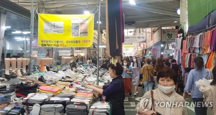 지난달 18일 오후 대구 중구 서문시장 한 양말 가판대 앞에 '대구광역시 선불카드, 온누리상품권, 정부 재난지원카드'로 결제가 가능하다는 안내 현수막이 걸려있다. / 사진=연합뉴스