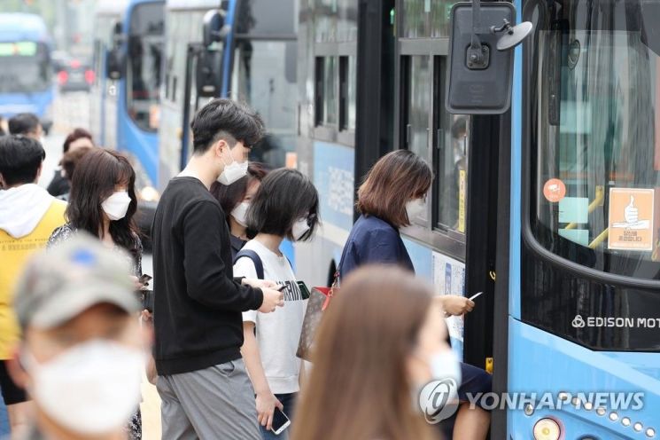 지난달 25일 오후 서울 서초구 고속터미널역 인근 버스정류장에서 마스크를 착용한 시민들이 버스를 이용하고 있다/사진=연합뉴스