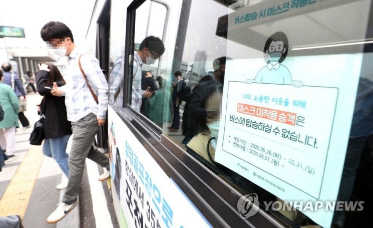 대중교통 이용 때 마스크 착용 의무화 시행 첫날인 26일 오전 서울역 환승센터에서 시민들이 마스크를 쓰고 버스를 이용하고 있다. [이미지출처=연합뉴스]
