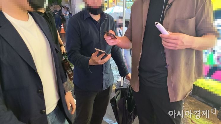 QR코드 기반의 전자출입명부 시스템이 도입된 10일 강남역 인근 한 감성주점에서 직원이 방문객들에게 QR코드 사용법을 설명하고 있다./사진=송승윤 기자