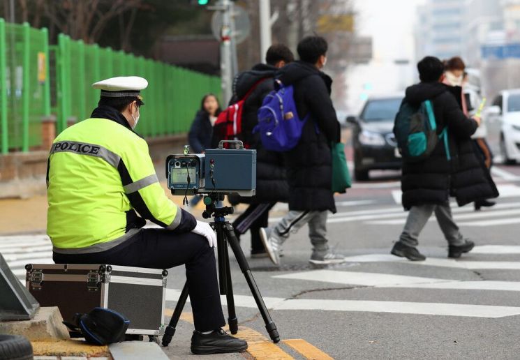 지난해 12월 대전 서구 둔산동의 한 초등학교 앞에서 한 경찰관이 차량의 불법 행위를 감시하고 있다. / 사진=연합뉴스