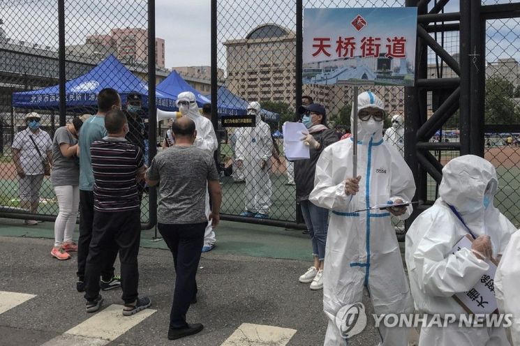 15일 중국 베이징 신파디 시장을 방문했거나 시장 인근에 사는 사람들이 코로나19 검사를 받으려고 줄을 서고 있다. / 사진=연합뉴스