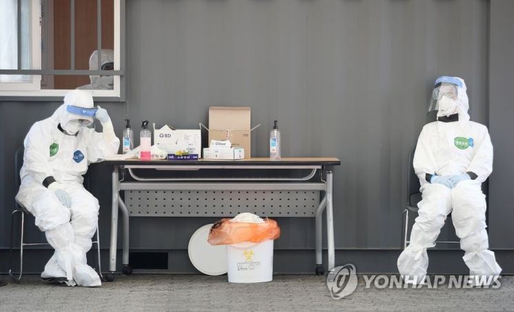 지난 3월23일 오후 송파구 잠실야구장에 설치된 드라이브 스루 선별진료소에서 의료진이 의자에 앉아 잠시 쉬고 있다. / 사진=연합뉴스