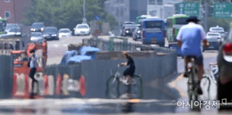 낮의 길이가 가장 길다는 여름의 네 번째 절기, '하지'이자 무더운 날씨를 보인 21일 서울 영등포구 여의대로에 지열로 인한 아지랑이가 피어오르고 있다. 기상청은 이날 폭염특보를 통해 경기 동부와 강원 영서는 23일까지 체감온도가 33도 이상 오르겠으며 매우 덥겠다고 전망했다. 또 23일까지 대부분 내륙은 체감온도가 31도 이상, 특히, 중부 내륙과 경북 내륙은 33도 이상으로 폭염특보가 확대될 가능성이 있겠다고 예보 했다./김현민 기자 kimhyun81@