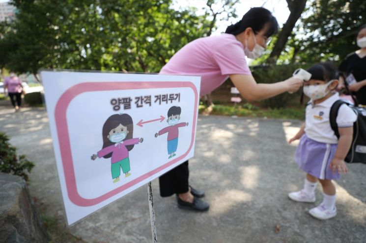 정상 등원을 시작한 22일 오전 대구시 중구 대구 백합어린이집에서 어린이가 교실에 들어가기 전 발열 체크를 받고 있다. [이미지출처=연합뉴스]