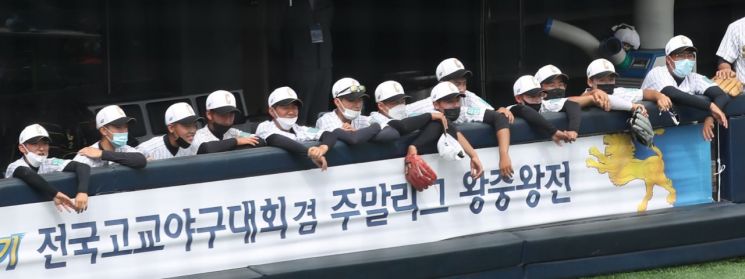 지난 11일 오전 서울 양천구 목동종합운동장에서 열린 제74회 황금사자기 전국 고교야구대회 겸 주말리그 왕중왕전에서 선수들이 더그아웃에서 마스크를 쓴 채 경기를 지켜보고 있다/사진=연합뉴스