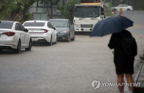 강원 영동지방을 중심으로 기록적인 폭우가 쏟아진 지난달 30일 오전 강릉 시내에서 시민이 출근길을 재촉하는 모습.사진=연합뉴스