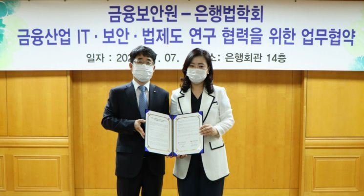 김영기 금융보안원장(왼쪽)이 안수현 은행법학회장과 업무협약을 체결하고 기념촬영을 하고 있다.
