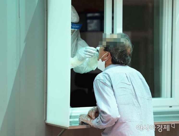 8일 서울 광진구보건소 신종 코로나바이러스 감염증(코로나19) 선별진료소 앞에 설치된 옥외 검체채취 부스에서 한 시민이 진료를 받고 있다. /문호남 기자 munonam@