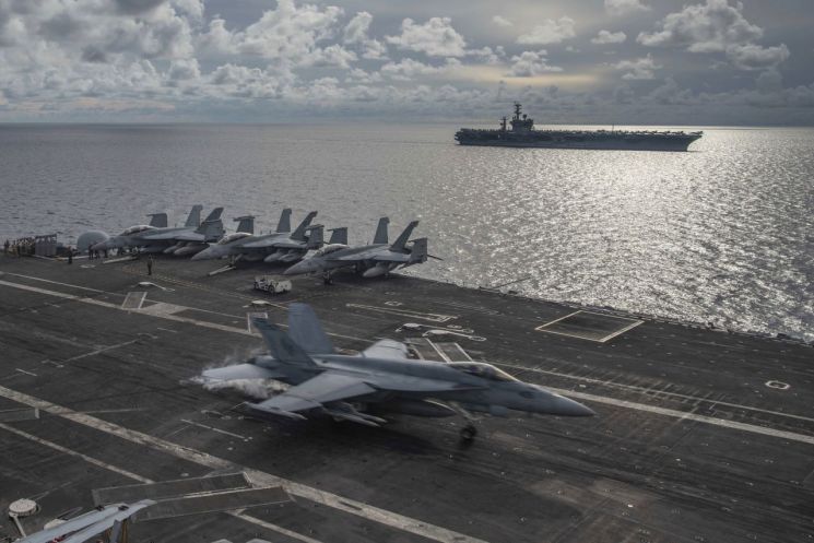 미국 해군 소속 F/A 18E 슈퍼호넷 전투기가 6일 남중국해 해역을 항해하는 니미츠 항공모함의 비행 갑판 위에 착륙하고 있다. [사진=AP.연합뉴스]