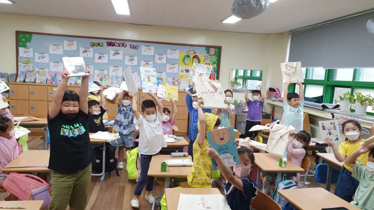 거창군 아림초등학교 학생들이 책꾸러미를 받아 즐거워하고 있다.(사진=거창군청)