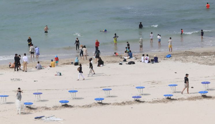 제주도 내 해수욕장의 공식개장을 하루 앞둔 지난달 30일 제주시 조천읍 함덕해수욕장에서 관계자들이 파라솔 테이블을 설치하고 있다.<이미지:연합뉴스>